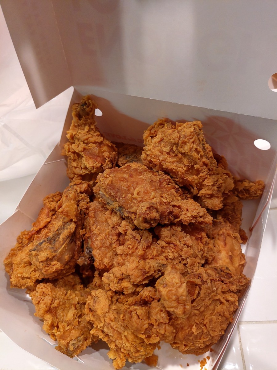 白色外卖盒里码着金黄酥脆的炸鸡，桌上光线暖黄