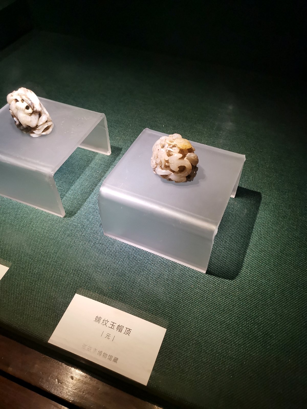 展柜中一方元代螭纹玉帽顶