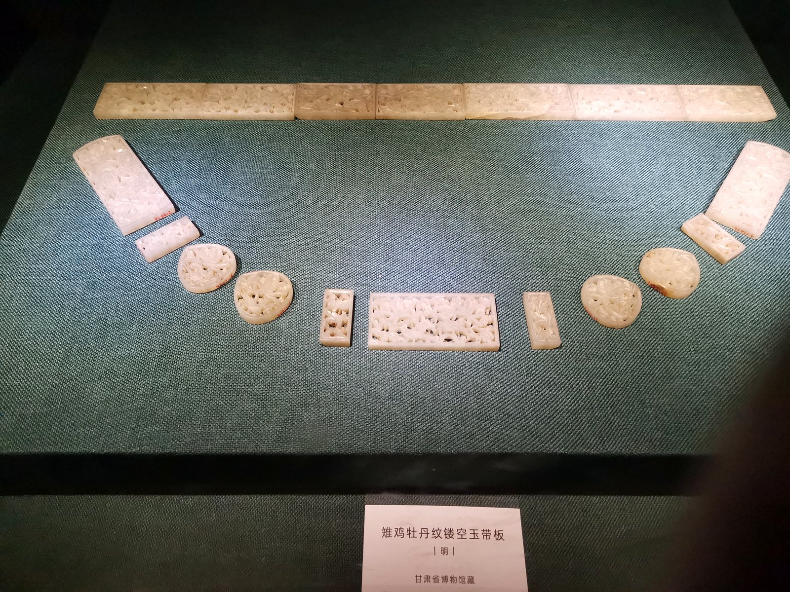 展柜中明代雉鸡牡丹纹镂空玉带板成排陈列