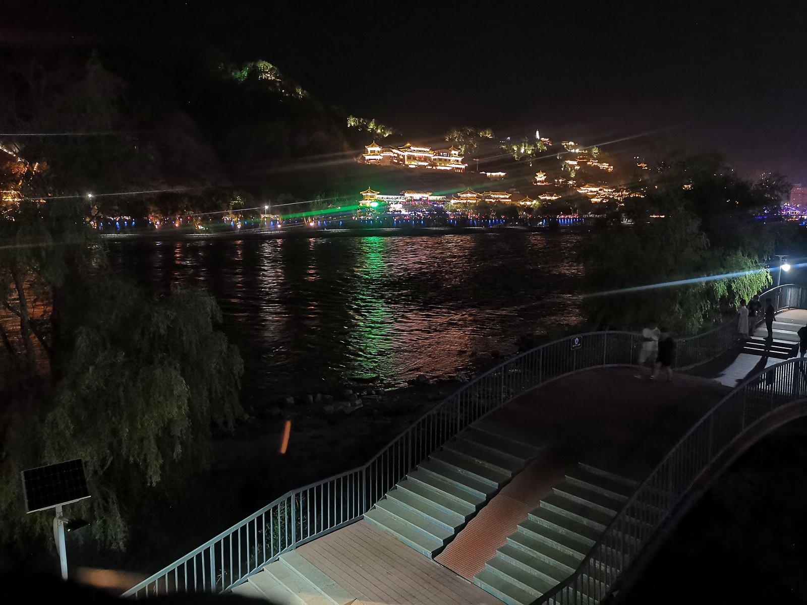 夜色里的黄河人行桥，对岸山坡灯火如瀑